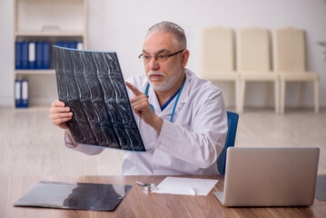 Old male doctor radiologist working in the clinic