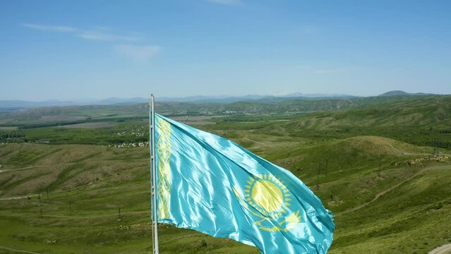 observation deck of city of Ust-Kamenogorsk with the flag of Kazakhstan flying drone around with views of the city and the river, winter, bright sun