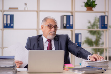 Old male boss working in the office