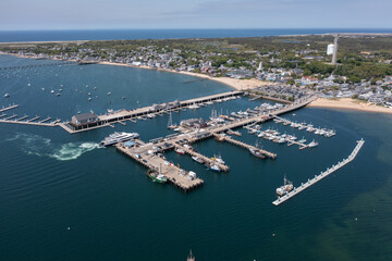 aerial landscape view of MacMillan Pier and Provincetown Marina in front and Provincetown city in...