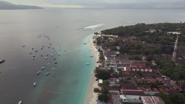 Aerial pull-away view showing boats in water on Bali Gilli Trawangan beach