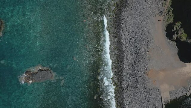 Birds Eye view of rock beach and clear water at Miradouro Ilh&eacute;us da Ribeira da Janela.