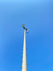 Projecteurs de stade sportif. Luminaire pour un terrain de sports extérieur. Lumière en haut d'un poteau pour un complexe sportif. Ciel bleu avec copy space.