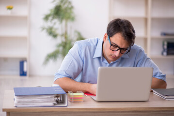 Fototapeta premium Young male employee working in the office