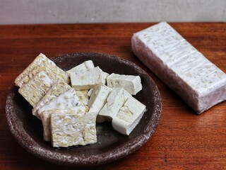 Slice of Tempeh and tofu on a wooden table
