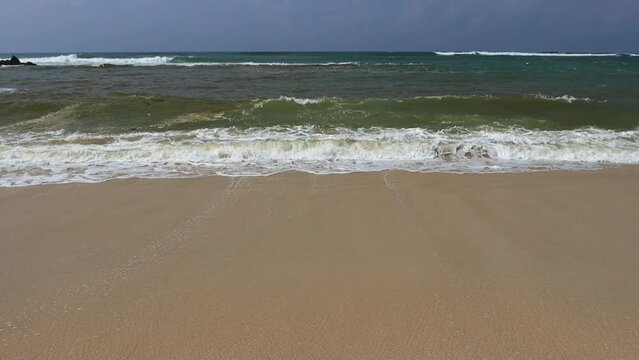 Wave and sand at the tropical beach. Beach slow motion video
