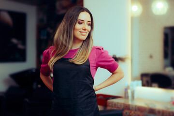 Hairdresser Wearing Uniform Standing in Hair Salon. Cheerful hairstylist working for her own business 
