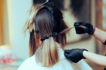 Hairdresser Sectioning Hair Using Some Hair Clips on a Client. Hairstylist using different clips to...