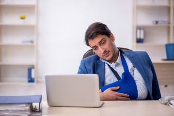 Young male employee after car accident at workplace