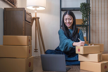 Happy young Asian woman entrepreneur, Smile for sales success after checking order from online...