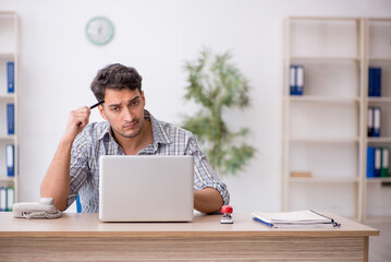 Young male employee working in the office