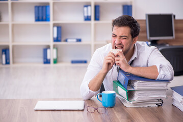 Young male employee feeling bad at workplace