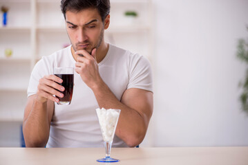Young male student testing soft drink