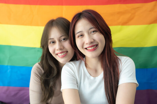 Couple lesbian with rainbow flag background. LGBTQ+ people enjoy activities celebrating equality sexual freedom and protecting the rights of individual.