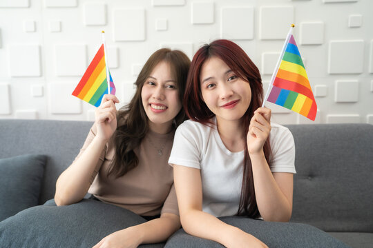 Woman at women empowerment strike holding rainbow flag. LGBTQ+ people enjoy activities celebrating equality sexual freedom and protecting the rights of individual.