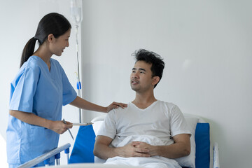 Fototapeta premium Physiotherapist giving advice and encouragement to male patient doing physiotherapy lying on patient bed to improve mentally and physically Psychological concept, health insurance.