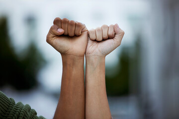 Fist, protest and power by people in solidarity for justice, human rights and democracy on blurred...