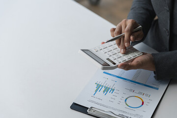 copy space, banner, panorama business woman working on the table Point to the data graph from the document on the chart. Use a calculator to calculate numbers. to analyze business growth plans.