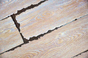 Top view of an old wooden laminate in an apartment or house damaged by moisture.