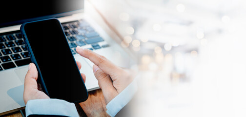 Black blank screen on mobile phone in business woman's hands who wearing formal suit with bright white bokeh blurred office interior background with copy space. Empty mock-up screen smartphone banner.