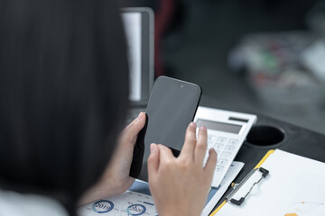 Young business woman on the phone at the office.Business woman texting on the phone and working on laptop.Beautiful young business woman sitting in office.Business woman smiling.