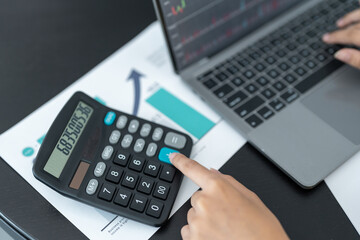 Closing of businessman or accountant hand working on calculator to calculate business data...