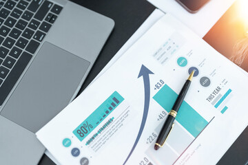business desk with keyboard report chart pen and tablet on black table