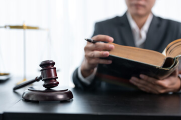Man lawyer reading legal book with gavel on table in modern office. justice and law ,attorney concept.