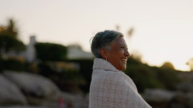 Sunset, laughing and senior woman at a beach with peace and smile outdoor. Nature, sea and elderly female person with mindfulness feeling calm, happy and relax by the ocean on retirement holiday