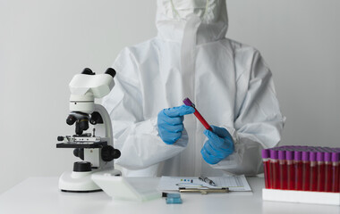 Fototapeta premium Technician, doctor, scientist in laboratory with blood sample tubes and rack In the laboratory holding a blood vessel sample for study, experiment, medical research biotechnology DNA testing.