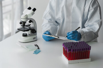 Technician, doctor, scientist in laboratory with blood sample tubes and rack In the laboratory holding a blood vessel sample for study, experiment, medical research biotechnology DNA testing.