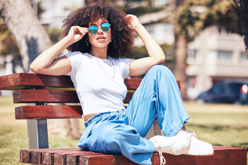 Fashion, bench and woman with sunglasses, portrait and summer with stylish clothes, trendy and gen z. Face, happy female person and girl outdoor, eyewear and casual outfit with beauty, edgy and relax - Powered by Adobe