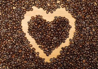 The whole coffee beans are photographed at the top corner and placed in the shape of a heart before being ground for drinking.
