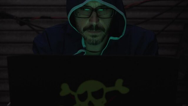 computer hacker with his laptop, celebrating that he has introduced a virus in the network
