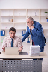 Old male boss and young male employee in bullying concept