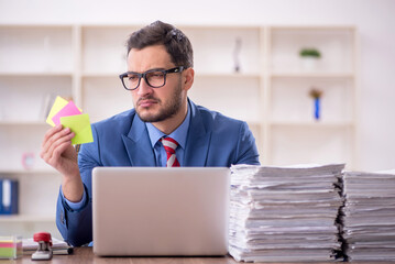 Young male employee unhappy with excessive work in the office