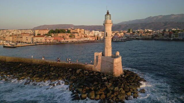 Aerial circling camera view of a Venetian era lighthouse in golden sunset light (Chania)