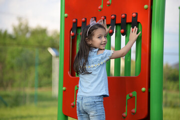 Cute little preschool girl is playing on the children's playground