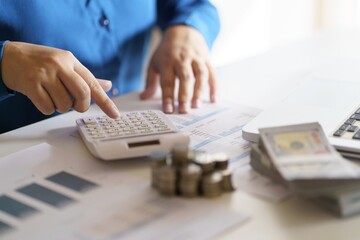 Business woman calculating financial statement on calculator income tax online return and payment.