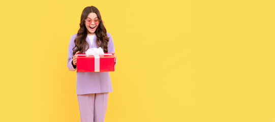 teenage shopper. stylish teen girl in jacket and eyeglasses hold gift box. shopping time. Kid girl with gift, horizontal poster. Banner header with copy space.