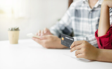 E-commerce Concept. Happy couple holding credit and using smartphone enter their card number in the mobile phone app to purchase and payment in internet store