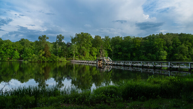 Foot bridge over the lake with reflections, stormy sky