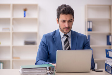 Young male employee and too much work in the office