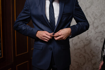 businessman puts on a suit. The man fastens the buttons on his jacket.