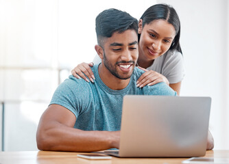 Couple, laptop and Indian man in a home with online shopping and ecommerce app with wife support. Mockup, young people and happiness from promotion email in a house at desk with woman supporting