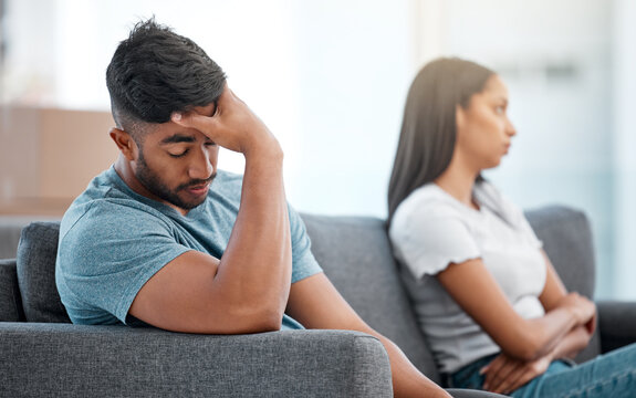 Couple, fight and frustrated man depressed on living room sofa with relationship problem. Divorce fear, cheating anxiety and marriage crisis of young people on a lounge couch at home thinking