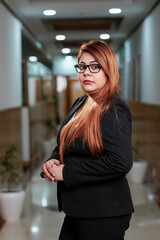 Young and confident corporate woman standing at office.