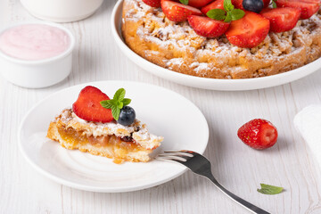 Piece of cake decorated with strawberries and blueberries
