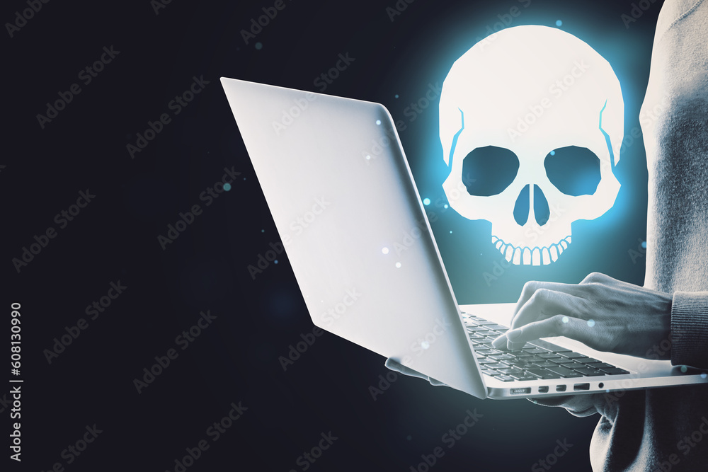 Poster Close up of hand using laptop computer with glowing white skull hologram on dark background with mock up place for your text. Cyber attack and malware concept.