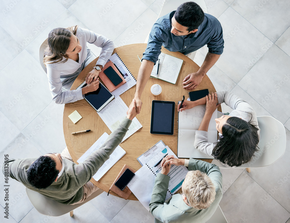Poster meeting, handshake and overhead with a business team sitting around a table in the office at work. p